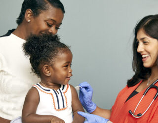 Toddler about to receive a vaccine from a doctor, image by SELF magazine