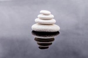 4 white stones in water, piled on top of each other