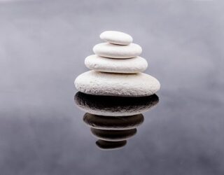 4 white stones in water, piled on top of each other