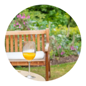 A glass with fresh juice on a table in a summer garden.